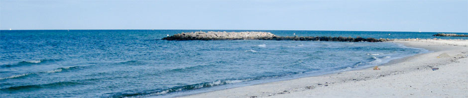 Heller Sandstrand mit Buhne und ruhiger Ostsee